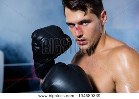 Close-up portrait of male boxer with bleeding nose at fitness studio