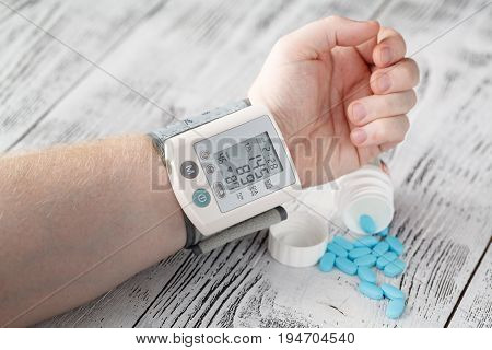 Tonometer High Blood Pressure Indication On The Male's Arm. Hypertension Medical Pills On The Backgr