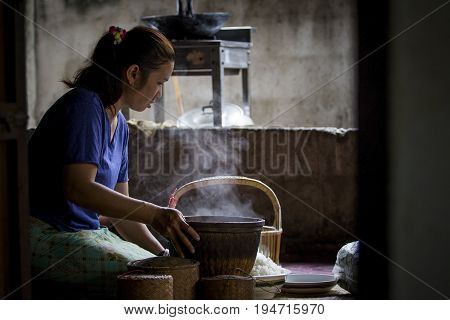 MAHASARAKHAM THAILAND - JULY82017 : thai north eastern woman prepare steaming sticky rice from bamboo basket for all day meal sticky rice most faverite and main food for thai north eastern
