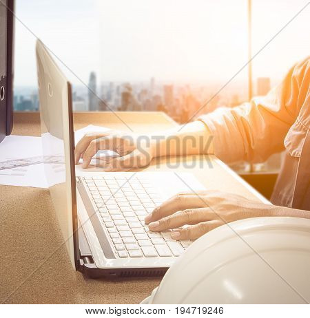 Silhouette hand business man working with smart phone and computer to work wireless. Press Trading business over blurred city. Concept boundless business and technology flare light.selected focus.