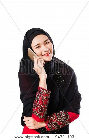 Beautiful young muslim woman using moblie phone on a white background.