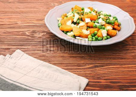 Warm salad with roasted pumpkin, peas and cheese brie. Low fat healthy eating concept.