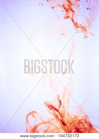 Ink swirl in a water on color background. The paint splash in the water. Soft dissemination a droplets of colored ink in water close-up. Abstract background. Explosion of splashes acrylic ink.