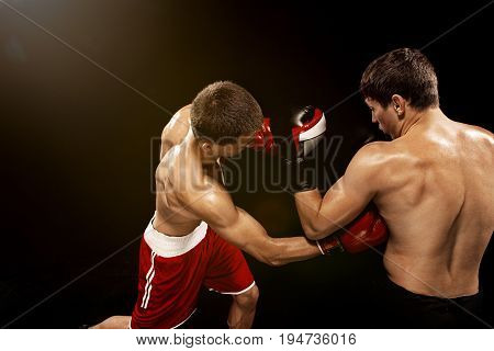 Two professional boxer boxing on black studio background.