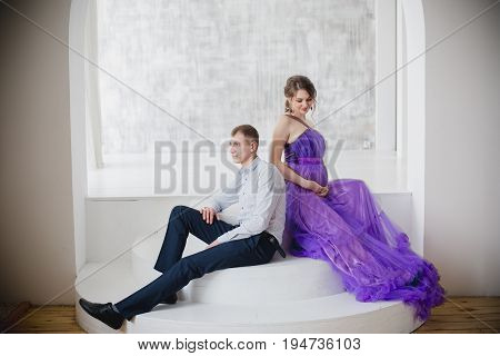 pregnant woman and man posing together in Studio, happy waiting
