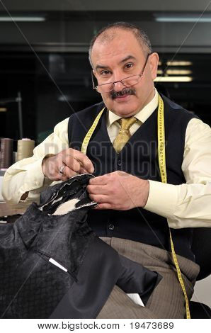 Tailor with measure sewing a jacket - a series of TAILOR related images.