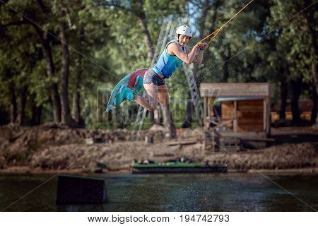 Woman in a jump with a board she is an extreme sportsman in training.