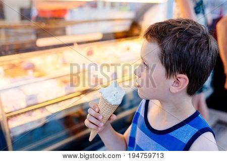 Small 7 years boy child eats delicious ice cream
