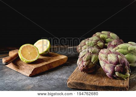 Baby Ripping Organic Artichokes With Lemon. Food For A Vegan And