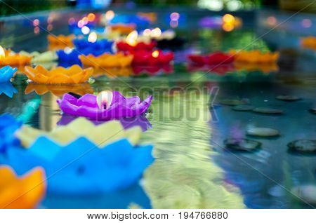 Lotus shape candle lit and float on water as sacred offering found in several religions and parts of the world. May be offering to gods respect person ancestor or nature spirits depending on belief.