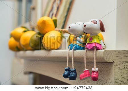 Close up two small figurines of happy dogs sit on shelf. Love concept
