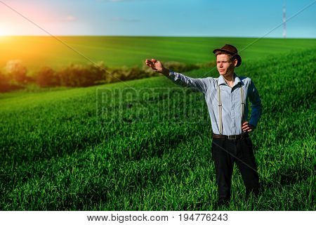 Man On The Field Shows On Elongated Hand Somewhere Far Into Something