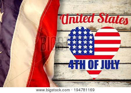Digitally generated image of heart shape American flag with text  against wood background