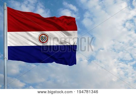 National flag of Paraguay on a flagpole in front of blue sky.
