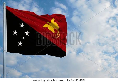 National flag of Papua New Guinea on a flagpole in front of blue sky.