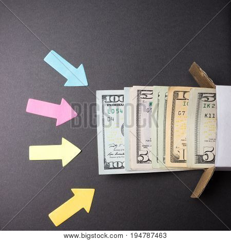 Arrows point to a stack of dollar bills looking out of the box. Increase in savings. Home safe. Business concept.