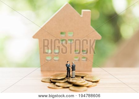 Miniature People,real Estate Investment. House And Coins On Table.