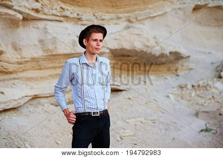 Stylish Attractive Man Stands In The Middle Of A Sand Quarry And Poses On The Camera