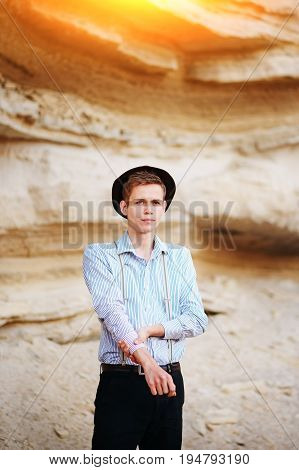 Stylish Attractive Man Stands In The Middle Of A Sand Quarry And Poses On The Camera