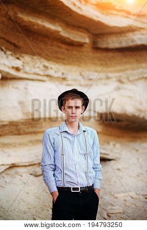Stylish Attractive Man Stands In The Middle Of A Sand Quarry And Poses On The Camera