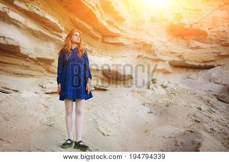 Beautiful Redheaded Girl Standing In A Blue Dress In The Middle Of A Sand Quarry
