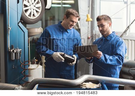 Best choice for our car. Successful trained scrupulous guy persuading his colleague the detail he wanting installing being good while using his tablet for this