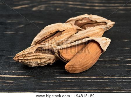 Wild uzbek inshell almonds on wooden background