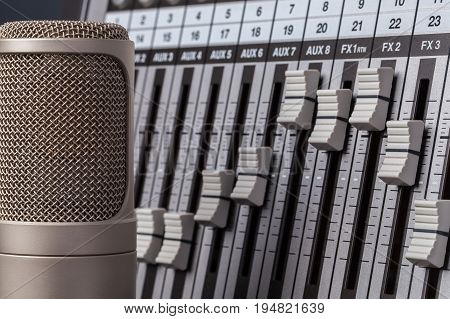 Audio recording equipment. Professional valve condenser microphone and studio mixing desk. Singer songwriter.