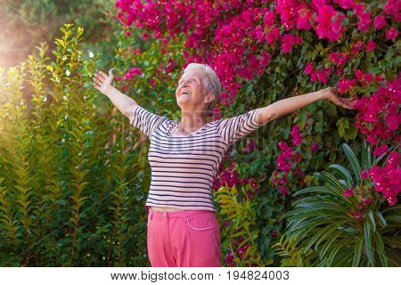 Christian senior woman arms outstretched with praise and joy