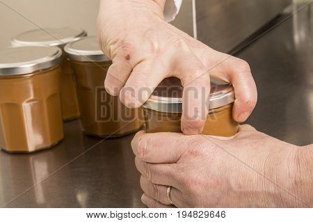 Automated food factory machine get the caramel jam in the jugs. Close up