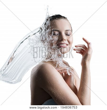 Young happy girl wrapped in towel washing up smiling tenderly her face in water splash