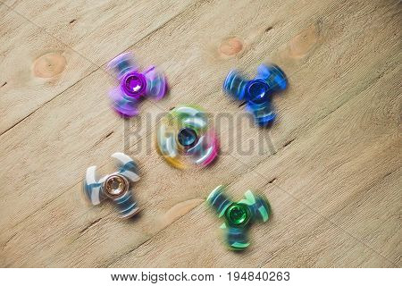 Colored Fidget Spinners Stress Relieving Toy On Wooden Background