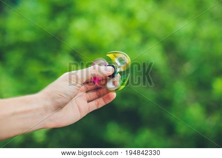 Close Up Of A Man's Hand Who Is Holding A Fidget Spinner In A Park