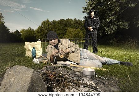 Vagabond young man sleeping in park checked by police patrol
