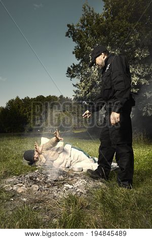 Vagabond young man sleeping in park checked by police patrol