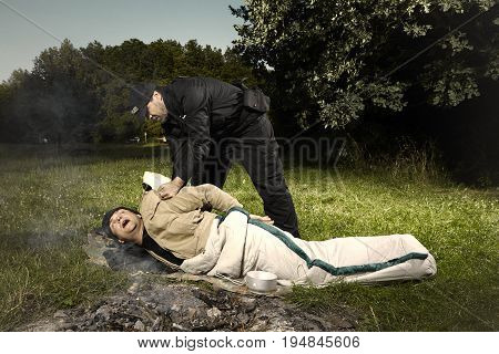 Vagabond young man sleeping in park catched by police patrol