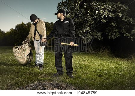 Vagabond young man catched in park by police patrol
