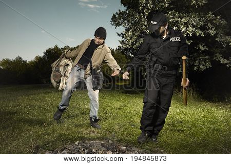 Vagabond young man catched in park by police patrol