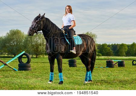 Pretty young girl riding a horse across country
