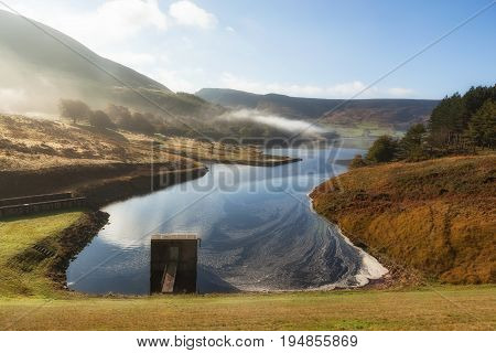 Spillway at the Dove stones reservoir with slightly mist and blue sky Oldham Saddleworth UK