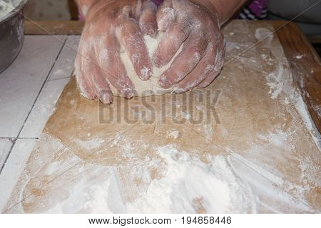 Top view shot of female hands mixing dough. Female hands knead dough on wooden board. 4k prores footage