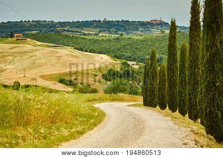 Sunset over the winding road with cypresses in Tuscany