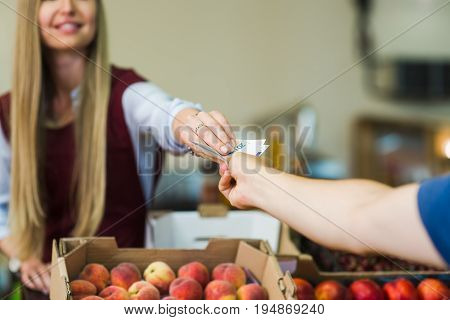 Young man paying cash at food market. Cash payment in close-up. Man pays in cash the seller of vegetables on the market.