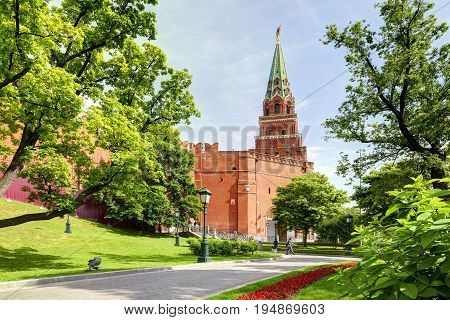 View on Moscow Red Square Kremlin tower Borovitskaya bashnya, Kremlin red brick wall, green trees and flowers of Alexander Garden (Aleksandrovskiy Sad). Famous sightseeing of Moscow Kremlin Red Square