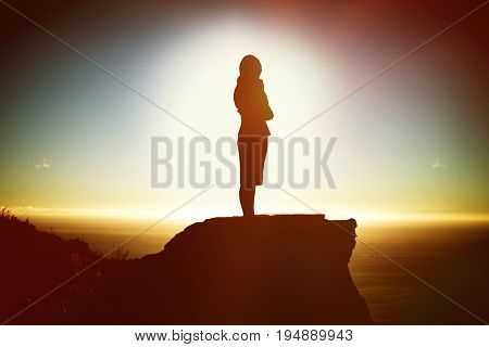 Thoughtful businesswoman standing isolated against white background against scenic view of mountain by sea against sky