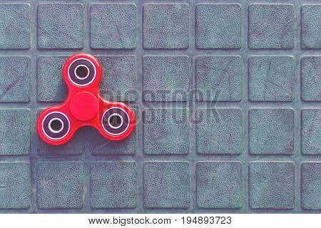 Top view of the popular red spinner gadget in 2017 on the blue-green background