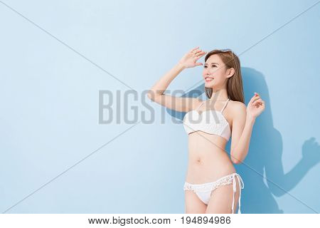 woman look somewhere and smile happily on the blue background