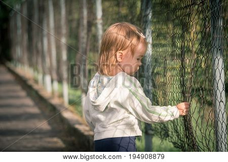 Little sad girl on walk in poor city