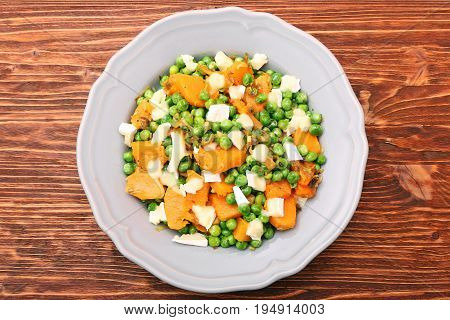 Warm salad with roasted pumpkin, peas and cheese brie. Low fat healthy eating concept.