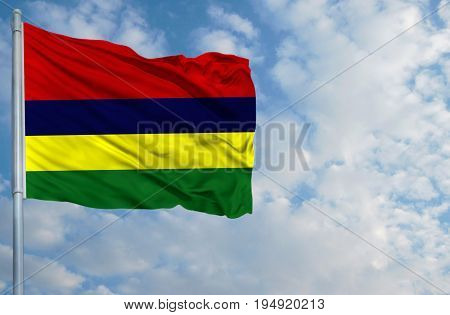 National flag of Mauritius on a flagpole in front of blue sky.